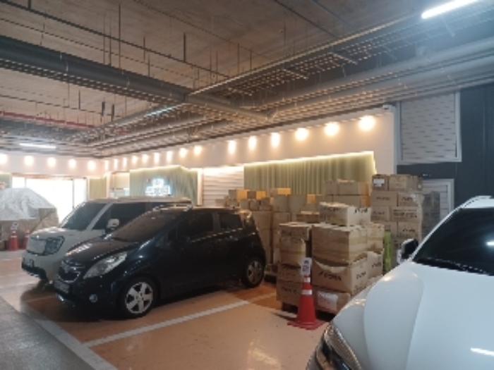 차량 두대가 주차되어 있고 물건이 적재되어 있는 곳은 본건 4번 415호 출입문