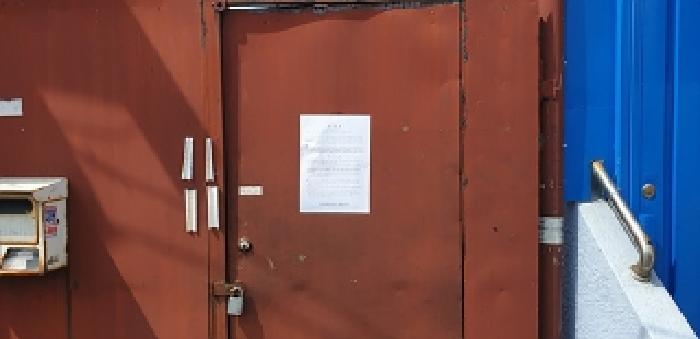 본 부동산 출입문 안내문 부착 모습
