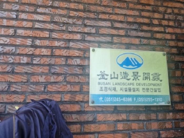 `부산조경개발` 상호가 마당 안 1층 벽면에 부착되어 있음.