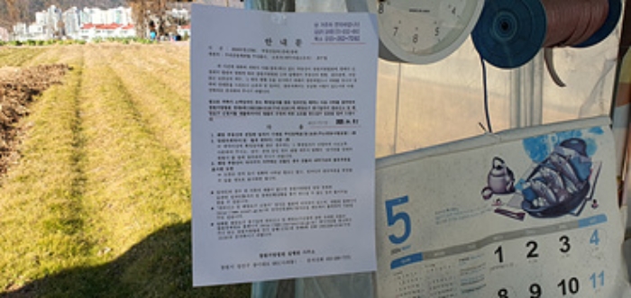 비닐하우스 입구쪽에 부동산경매 사건에 대한 안내문 게시