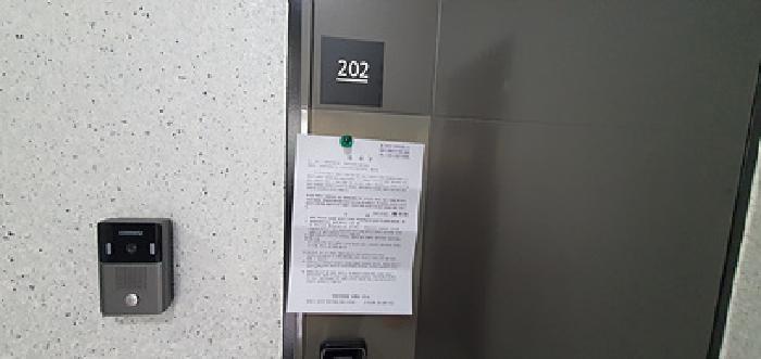 202호 출입문에 부동산경매 사건에 대한 안내문 게시(3/13일)