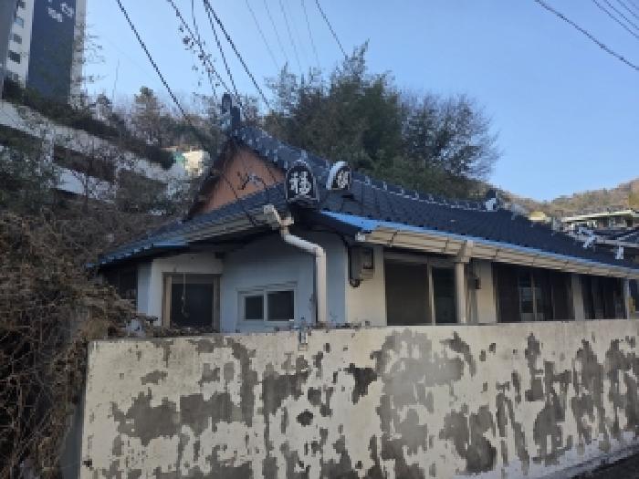 본건 부동산의 측면 모습(대지위에 콘크리트와 함석지붕으로 된 단층 건물 있음)